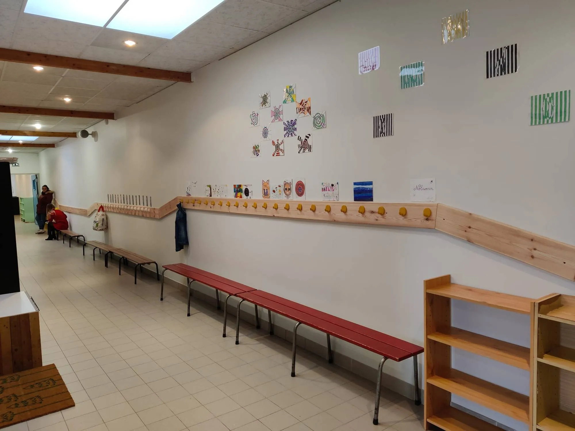 Couloir de l'école avec dessins d'enfants, stockage de chaussons et chaussures